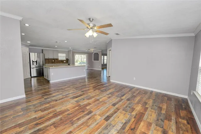a view of an empty room with window and wooden floor