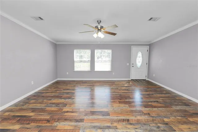 a large kitchen with stainless steel appliances a large counter top a stove a sink a refrigerator and a granite counter tops with white cabinets