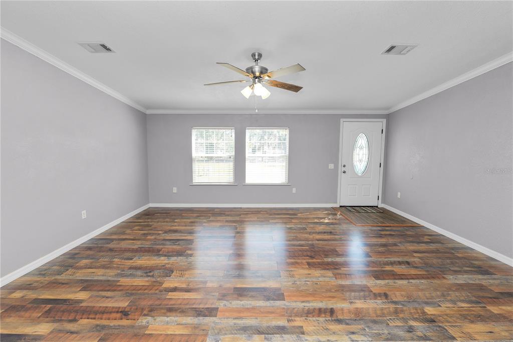 7405 Shoupe Road Plant City, FL 33565 - Photo 5 of 61 a view of an empty room with window and wooden floor