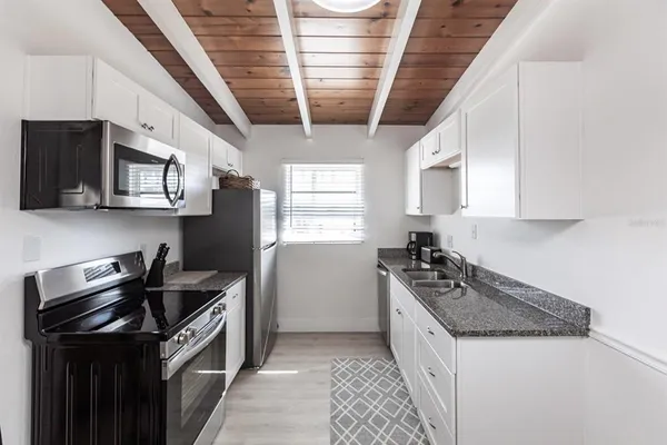a kitchen with stainless steel appliances granite countertop a stove a sink and a microwave