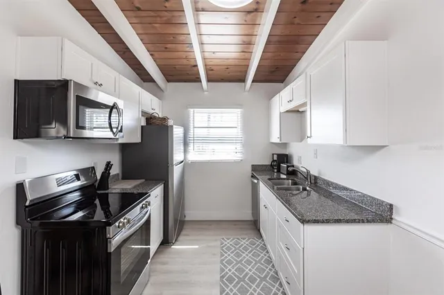 a kitchen with stainless steel appliances granite countertop a stove a sink and a microwave