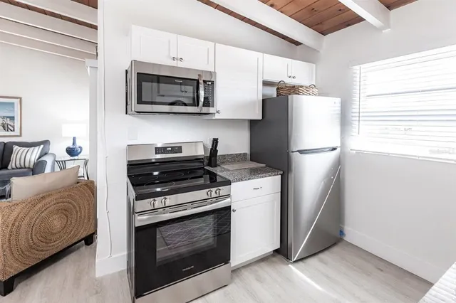 a kitchen with stainless steel appliances a stove a microwave and a refrigerator