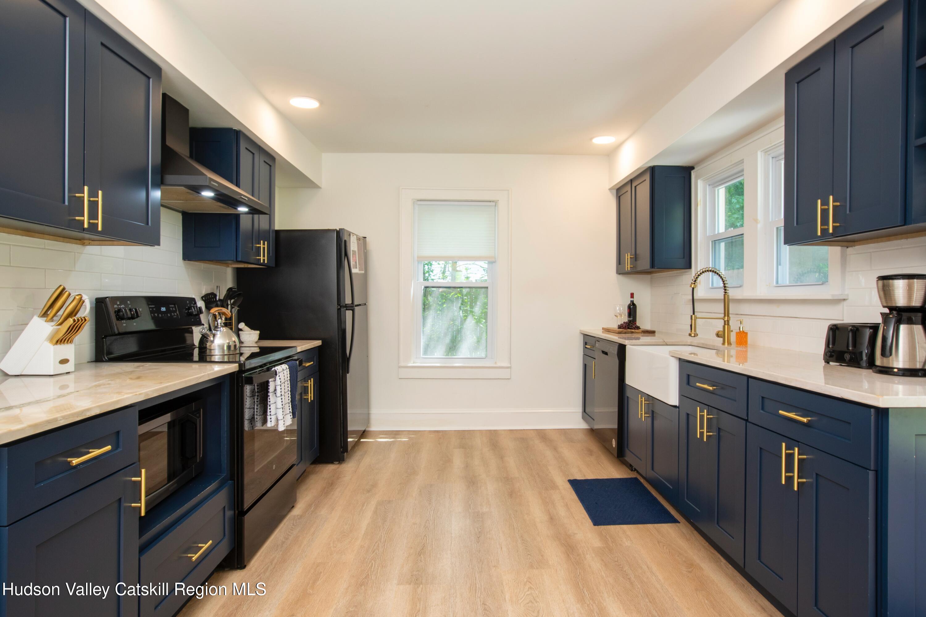 5813 Highway 44 Kerhonkson, NY 12446 - Photo 7 of 21 a kitchen with a sink a refrigerator and cabinets