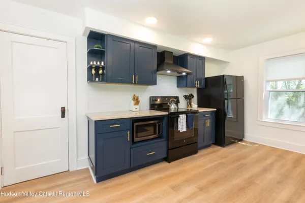 a kitchen with stainless steel appliances granite countertop a refrigerator a stove a sink and a oven