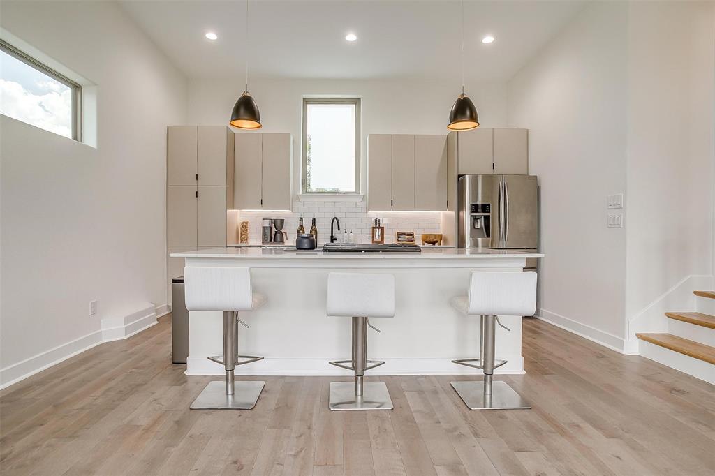 3231 Elihu Street, Unit 101 Dallas, TX 75210 - Photo 5 of 20 a kitchen with stainless steel appliances kitchen island granite countertop a sink and cabinets