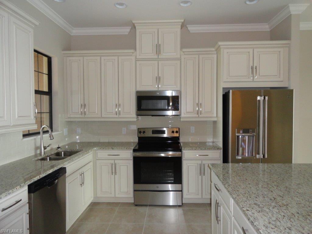 9685 Montelanico Loop, Unit 202 Naples, FL 34119 - Photo 12 of 21 a kitchen with granite countertop white cabinets and stainless steel appliances