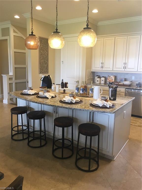 9685 Montelanico Loop, Unit 202 Naples, FL 34119 - Photo 13 of 21 a kitchen with a table chairs sink and cabinets