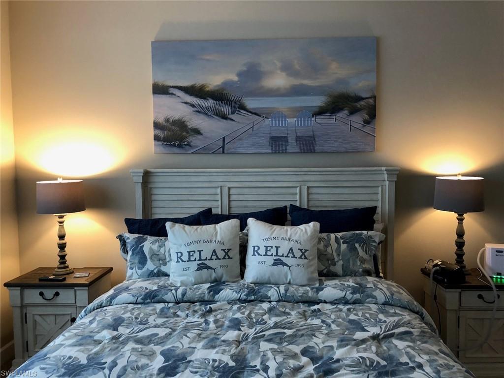 9685 Montelanico Loop, Unit 202 Naples, FL 34119 - Photo 15 of 21 a bed room with a bed and a lamp
