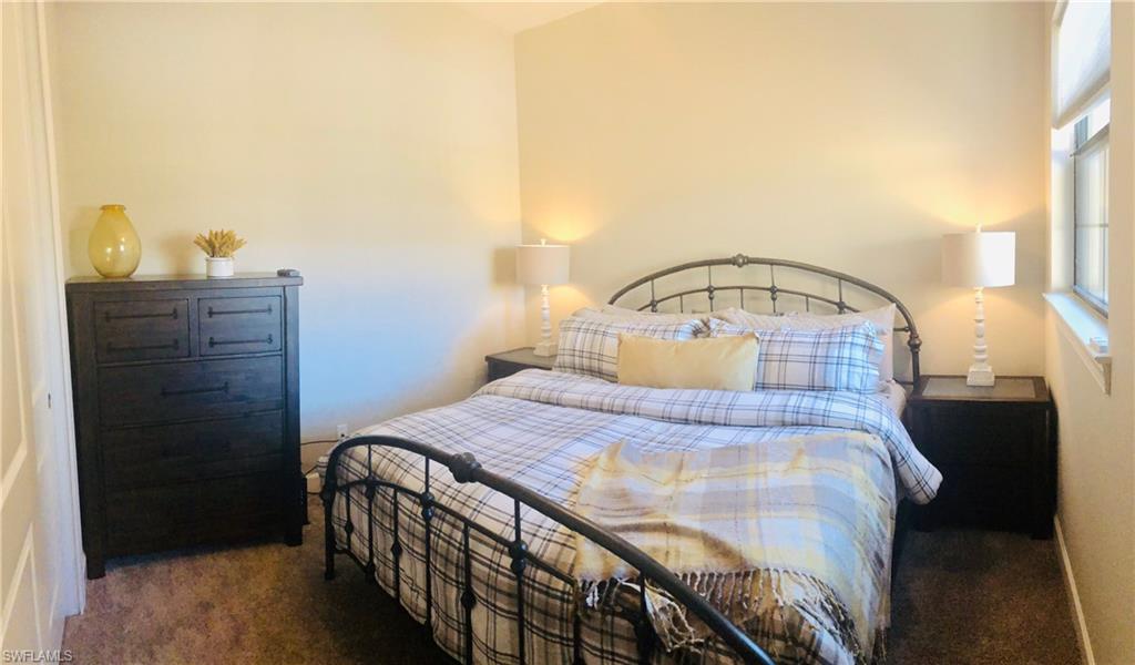 9685 Montelanico Loop, Unit 202 Naples, FL 34119 - Photo 18 of 21 a bedroom with a bed and a dresser