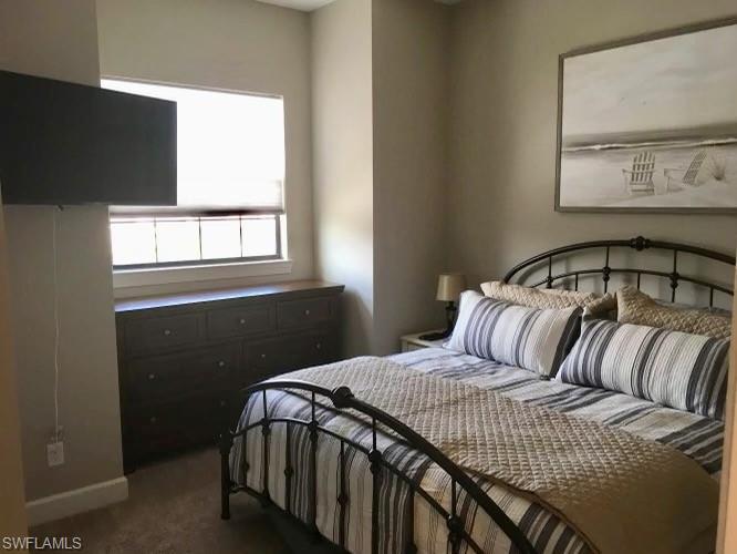 9685 Montelanico Loop, Unit 202 Naples, FL 34119 - Photo 19 of 21 a bedroom with a bed and wooden floor