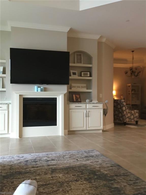 9685 Montelanico Loop, Unit 202 Naples, FL 34119 - Photo 5 of 21 a living room with stainless steel appliances kitchen island a fireplace and a television