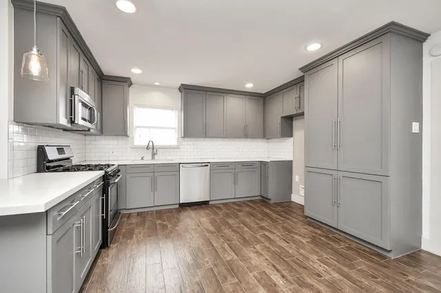 a kitchen with a refrigerator a sink and cabinets