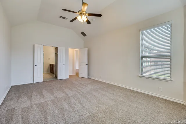 an empty room with windows and fan