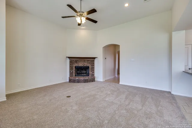 an empty room with fireplace and fan