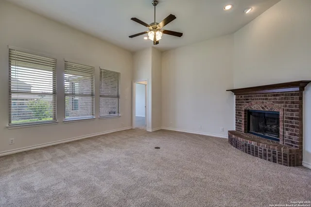 a view of an empty room with a fireplace and a window