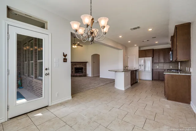 a kitchen with kitchen island granite countertop a refrigerator a oven a sink a island and a stove