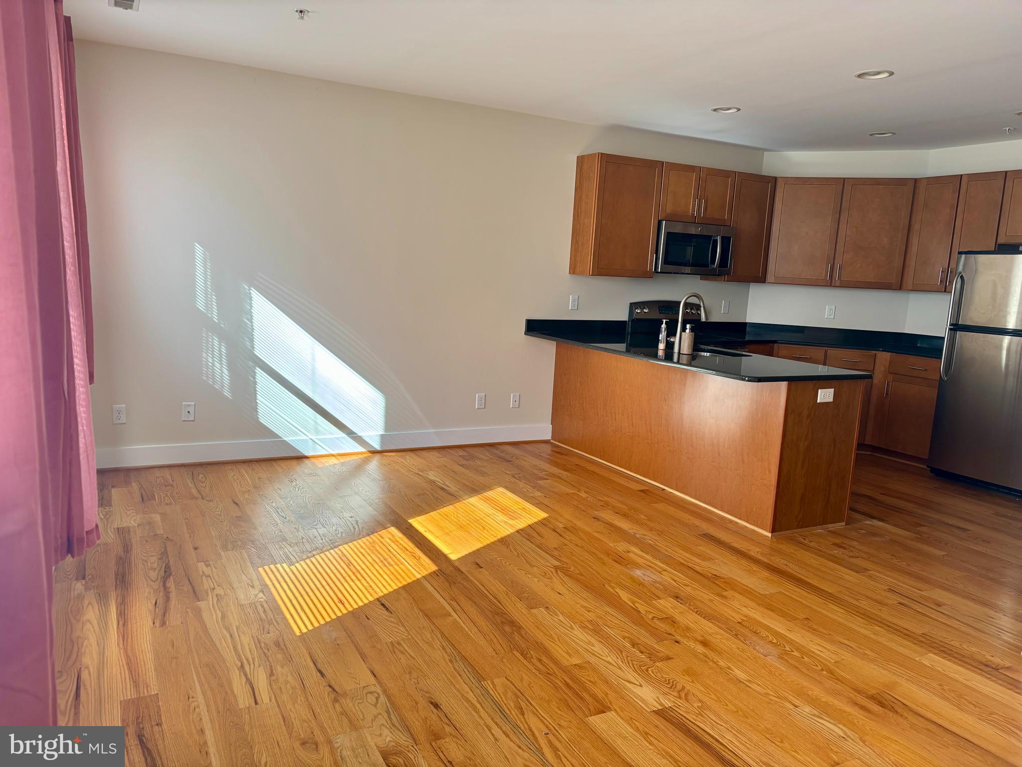 a kitchen with stainless steel appliances wooden floors and wooden cabinets