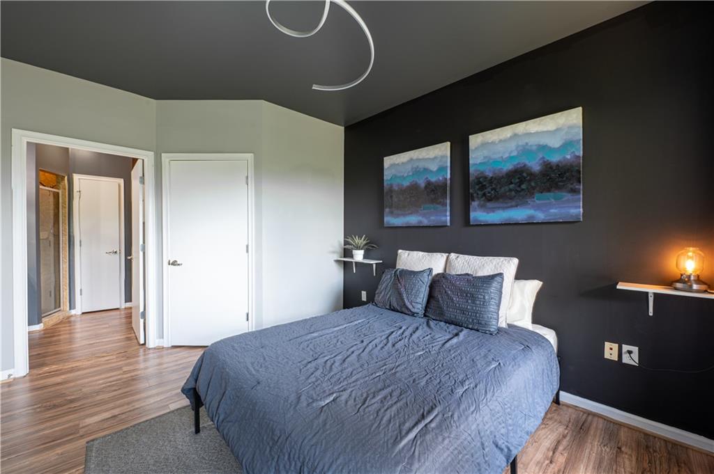 898 Oak Street Southwest, Unit 1410 Atlanta, GA 30310 - Photo 18 of 31 a bedroom with a bed and wooden floor