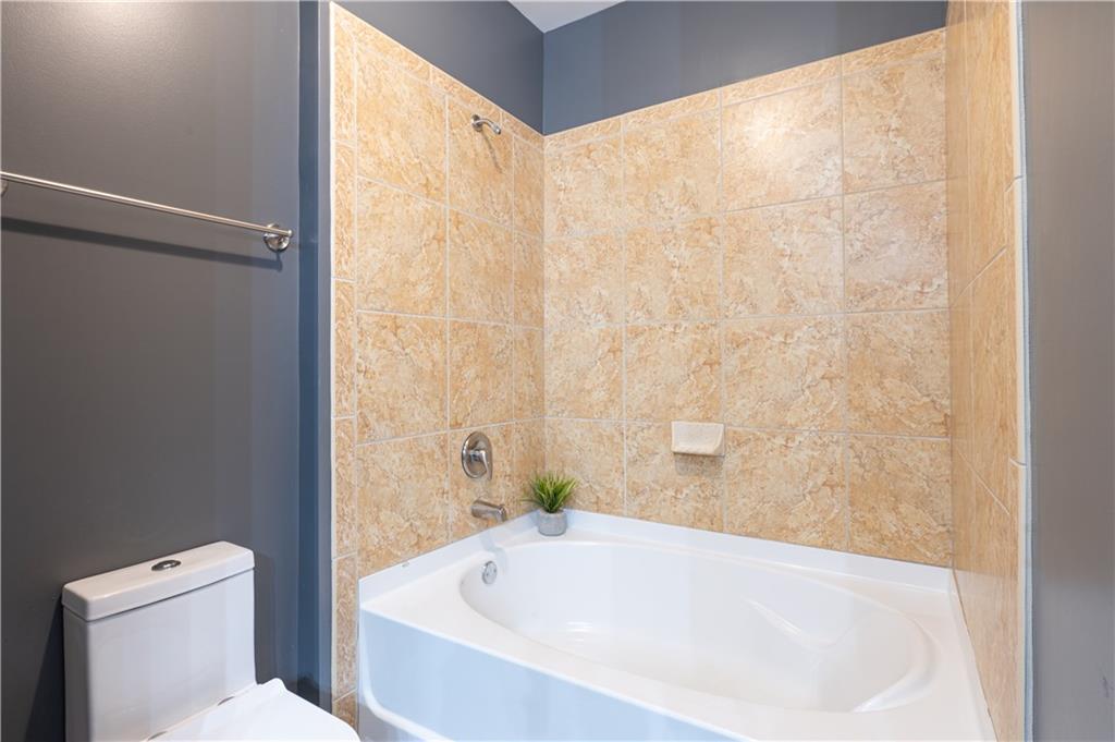 898 Oak Street Southwest, Unit 1410 Atlanta, GA 30310 - Photo 21 of 31 a white bath tub sitting next to a white toilet
