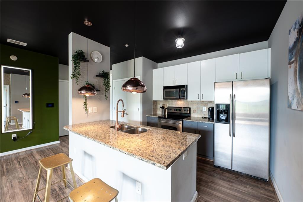 898 Oak Street Southwest, Unit 1410 Atlanta, GA 30310 - Photo 5 of 31 a kitchen with stainless steel appliances granite countertop a sink refrigerator and microwave