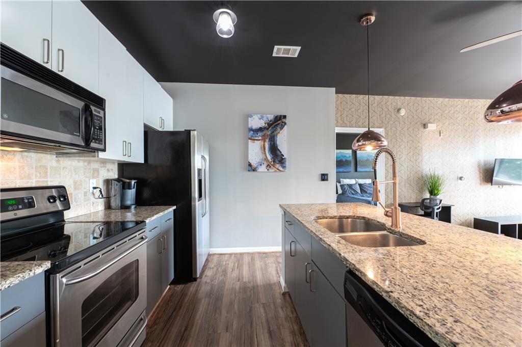 898 Oak Street Southwest, Unit 1410 Atlanta, GA 30310 - Photo 6 of 31 a kitchen with stainless steel appliances granite countertop a sink a stove oven and refrigerator