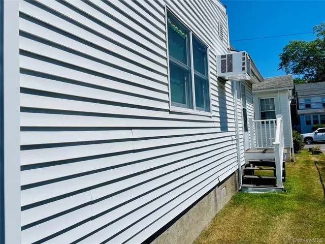 a view of backyard of house with deck and furniture
