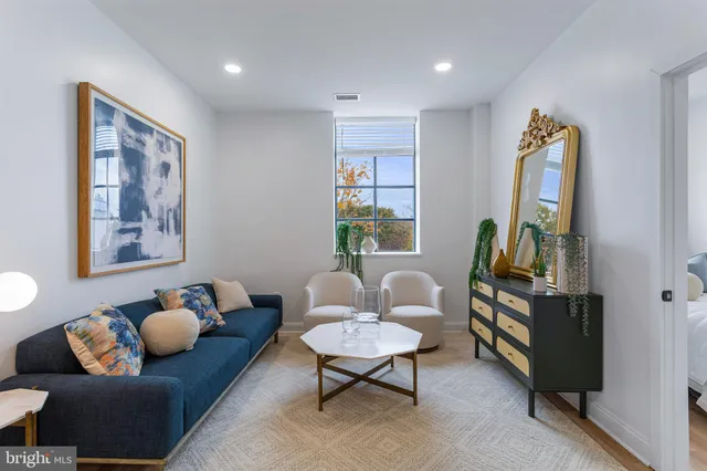 a living room with furniture a rug and a window