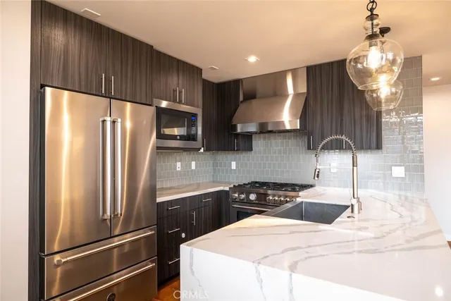 a kitchen with stainless steel appliances a refrigerator stove and sink