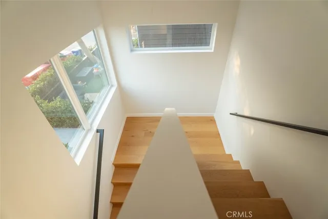 a view of a hallway with wooden floor and entryway
