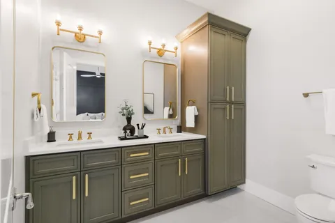 a bathroom with a double vanity sink mirror and toilet