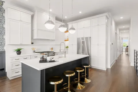 a kitchen with a sink a center island cabinets and stainless steel appliances