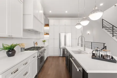 a kitchen with a sink a stove and cabinets