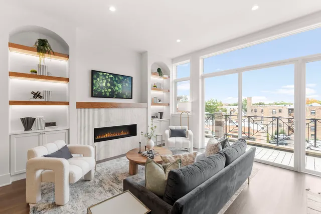 a living room with furniture fireplace and a large window