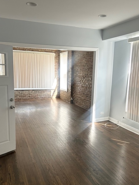 627 East 89th Place, Unit 2 Chicago, IL 60619 - Photo 2 of 9 an empty room with wooden floor and windows