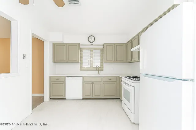 a kitchen with white cabinets and white appliances