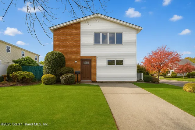a view of a house with backyard and trees