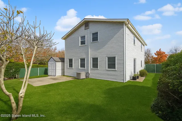 a front view of a house with a yard and trees