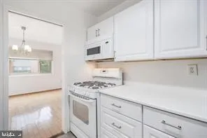 a kitchen with white cabinets and white appliances