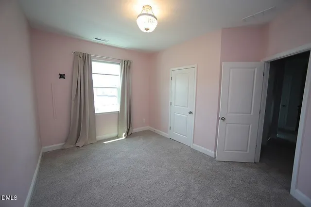 an empty room with windows and closet