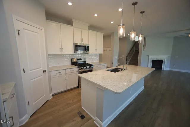 a kitchen with a sink a stove a microwave and cabinets
