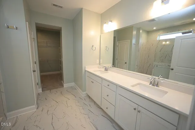 a spacious bathroom with a double vanity sink mirror and shower