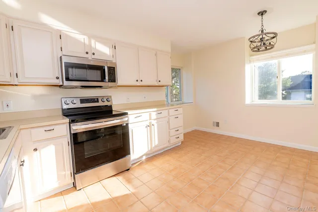 a kitchen with stainless steel appliances white cabinets and a stove