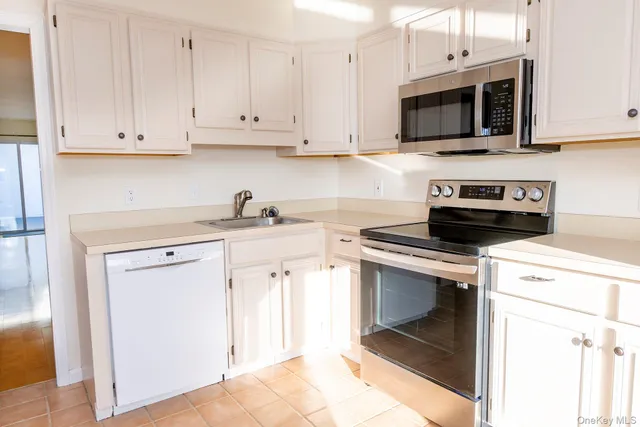 a kitchen with cabinets stainless steel appliances and a sink