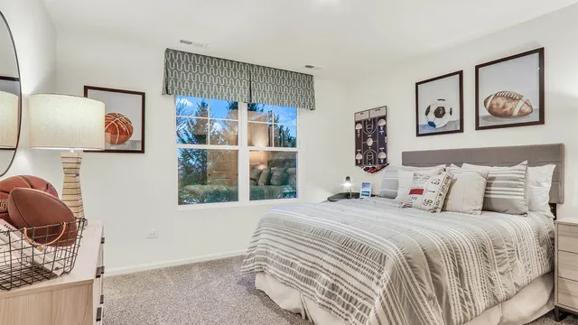 a bedroom with a bed and a lamp on dresser