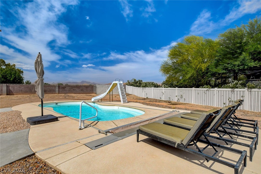 4362 Thistle Street Logandale, NV 89021 - Photo 75 of 99 An inviting backyard oasis offers a sparkling in-ground pool with slide and ample space for lounging.