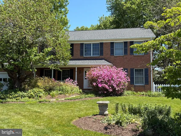 a front view of a house with a yard and potted plants