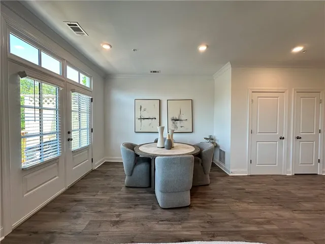a dining room with kitchen island stainless steel appliances furniture stove and wooden floor