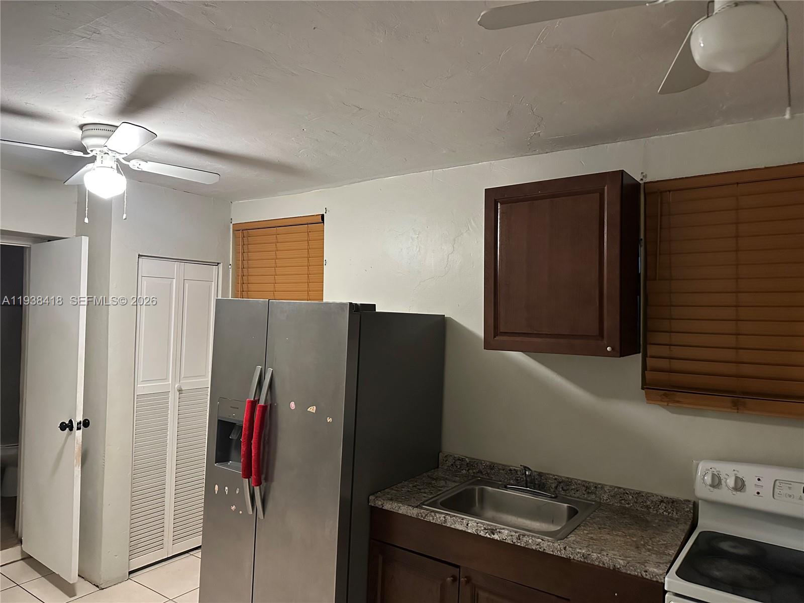 465 Northeast 157th Terrace, Unit 2 Miami, FL 33162 - Photo 5 of 9 a kitchen with a refrigerator and a stove