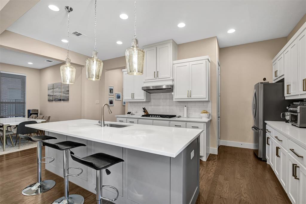 1026 Billy Lane Allen, TX 75013 - Photo 12 of 32 a kitchen with kitchen island a stove a table and chairs in it
