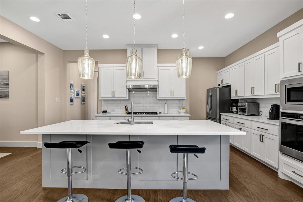 1026 Billy Lane Allen, TX 75013 - Photo 10 of 32 a kitchen with stainless steel appliances kitchen island granite countertop a dining table chairs refrigerator and sink